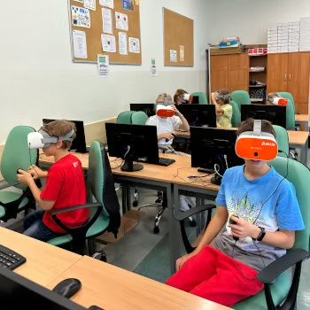 Uczniowie w goglach VR oglądają wirtualną rzeczywistość.